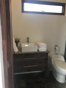 a bathroom with a white toilet and a sink at Despierte con la naturaleza in Cogua