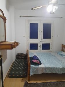 um quarto com uma cama, uma cadeira e 2 janelas em مارسيليا بيتش ١ شاليه em Dawwār Abū al ‘Āşī