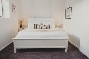 a white bedroom with a large white bed in it at Reardon Retreat in Port Fairy