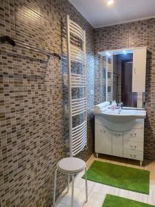 baño con lavabo, taburete y alfombra verde en Holiday home in Heviz - Balaton 44882 en Hévíz