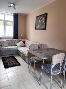 Holiday home in Heviz - Balaton 44882 في هفيز: غرفة معيشة مع أريكة وطاولة وكراسي