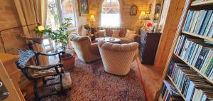 uma sala de estar com cadeiras, uma mesa e livros em Holiday home in Balatonendred 44893 em Balatonendréd