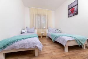 シロにあるHoliday home in Silo - Insel Krk 44633の木製の床の白い部屋にベッドが2つある