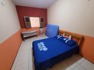 a bedroom with a blue bed and a chair at Casa de praia, Camocim. in Camocim