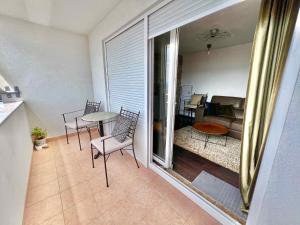 uma varanda com mesa e cadeiras e uma sala de estar em Apartments in Crikvenica 44153 em Crikvenica