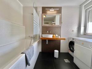 uma casa de banho com um lavatório e uma máquina de lavar roupa em Apartments in Crikvenica 44153 em Crikvenica