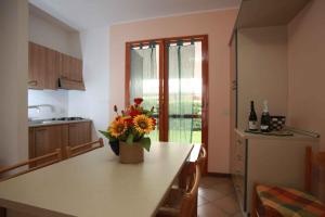 una cocina con una mesa con un jarrón de flores. en Apartment in Rosolina Mare 44965, en Rosolina Mare