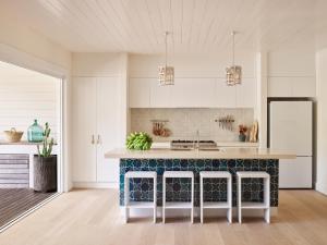 uma cozinha com armários brancos e um balcão azul em Atlantic Byron Bay em Byron Bay