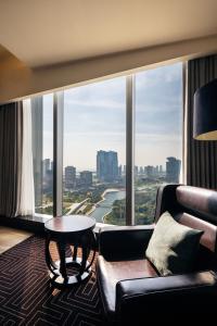 a living room with a couch and a table and a large window at Sheraton Grand Incheon Hotel in Incheon