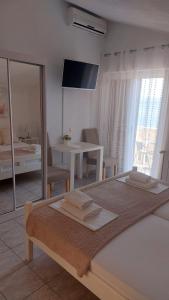 a bedroom with a bed and a table and a mirror at Apartments Duce (122) in Duće +120 photos