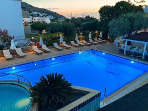 a large swimming pool with chairs and a hotel at Lindos Athena in Lindos