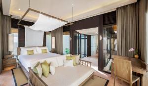 The Naka Island, a Luxury Collection Resort & Spa, Phuket في Ko Naka: غرفة نوم بسرير واريكة في غرفة