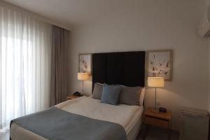 Een bed of bedden in een kamer bij Wyndham Kusadasi Golf&Spa 2 1 Butik Şık Tatil Evi C 233