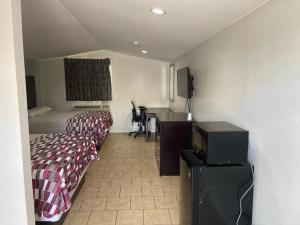 コーパスクリスティにあるSafari Inn Motelのベッド2台とテレビが備わるホテルルームです。