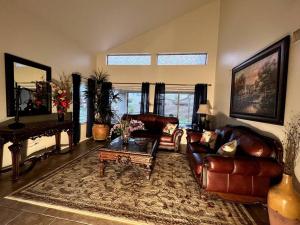 een woonkamer met lederen meubels en een piano bij La Posada de Lucy, LLC in Phoenix