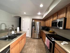 uma cozinha com armários de madeira e um frigorífico de aço inoxidável em La Posada de Lucy, LLC em Phoenix