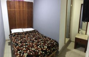 a small bedroom with a bed with a brown headboard at HOTEL PUERTO MEXICO 2 in Mexico City