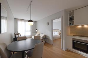 a living room with a dining room table and a bedroom at FLH Boavista Flat III in Porto