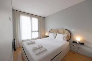 1 dormitorio con 1 cama grande y 2 bandejas. en FLH Boavista Flat III en Oporto