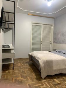 a bedroom with a bed and a dresser in it at Pousada Hostel Dodora in Bento Gonçalves