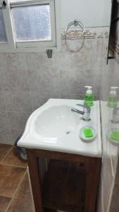 um lavatório de casa de banho com uma garrafa de sabão verde em La Toscana em Rocha