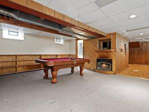 a pool table in a room with a fireplace at Convenient 5 bedroomMetro Milwaukee Brewers! in West Allis