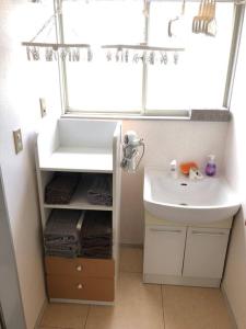 ein Bad mit einem Waschbecken und einem Fenster in der Unterkunft Chichibu Mizuno-stay 水野ステイ最大６名様 in Chichibu