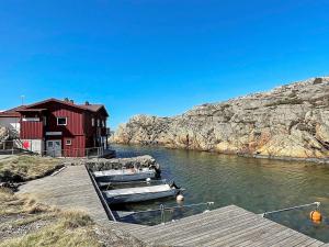 NösundにあるHoliday home Nösund IXの水上の赤い建物の隣に2隻の船が停泊している