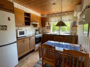 a kitchen with a table and a white refrigerator at Holiday home Nösund IX in Nösund