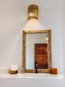 baño con espejo y lavabo en Vila Caiada Guest House en Luis Correia