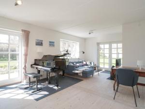 een woonkamer met een piano en een bank bij Holiday home Tisvildeleje XVII in Tisvildeleje