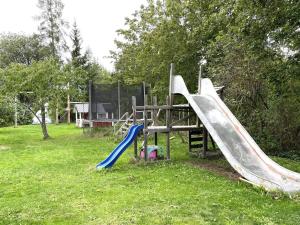 een speeltuin met een glijbaan in het gras bij Holiday home Vikingstad in Vikingstad