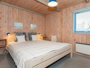 um quarto com uma cama grande numa parede de madeira em Holiday home Pandrup XXXIII em Pandrup
