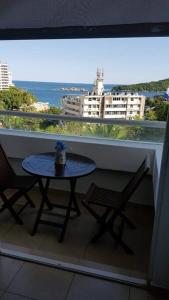 a balcony with a table and two chairs and a window at Departamento con vista al mar, albercas y juegos in Acapulco