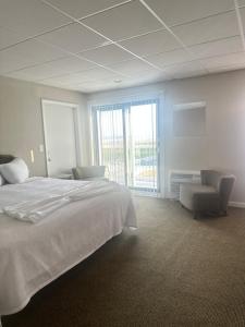 a bedroom with a large white bed and a chair at Waikiki Oceanfront Inn in Wildwood Crest