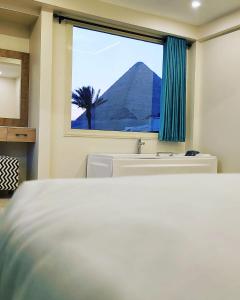 een slaapkamer met een bed, een wastafel en een raam bij The Gate Hotel Front Pyramids & Sphinx View in Caïro