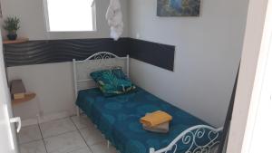 a small room with a bed with a blue and white at Bungalow Les Iguanes - CocoCyrna in Sainte-Anne