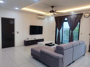 a living room with a couch and a flat screen tv at SkyView in Johor Bahru