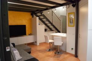 a living room with a staircase and a room with chairs at Mo&Vi - Elegante Loft - Vicino F1-San Gerardo-Parco Monza in Lissone