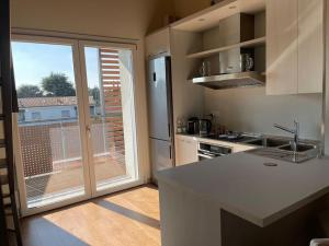 a kitchen with a counter and a large window at Mo&Vi - Elegante Loft - Vicino F1-San Gerardo-Parco Monza in Lissone