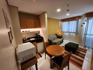 a small living room with a table and a kitchen at Residence Flat 143 em Santana in São Paulo