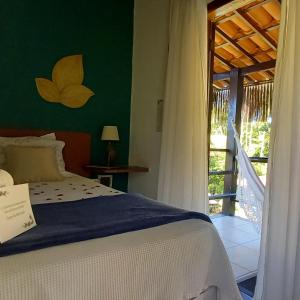 a bedroom with a bed and a door to a balcony at Pousada Vila Mato Verde in Morro de São Paulo +185 photos