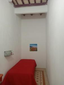 a bedroom with a red bed in a white room at Appartamento Lorena in Trapani