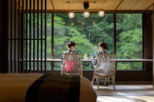 two people sitting at a table looking out of a window at Yamanakaonsen Ohanami Kyubei in Kaga