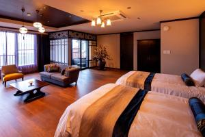 a hotel room with two beds and a couch at Kamisuwa Onsen Shinyu in Suwa