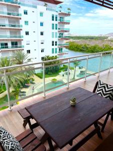 a wooden table on a balcony with a view of the water at 5010 depa Pacifika de lujo en Marina Mazatlán in Mazatlán +49 photos