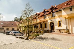 a building with a car parked in a parking lot at Hotel Lony in Mochov