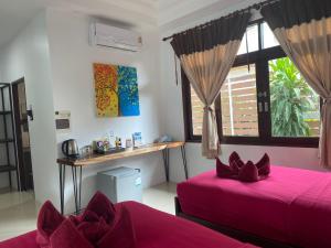 sypialnia z 2 łóżkami, biurkiem i oknem w obiekcie Amara Beach Resort Koh Phangan w mieście Haad Yao
