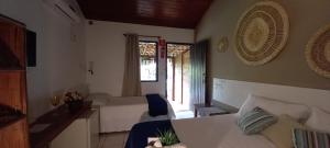 a hotel room with a bed and a window at Pousada Vila Mato Verde in Morro de São Paulo