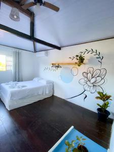 a bedroom with a bed and a flower on the wall at Aurora Hostel in Pipa